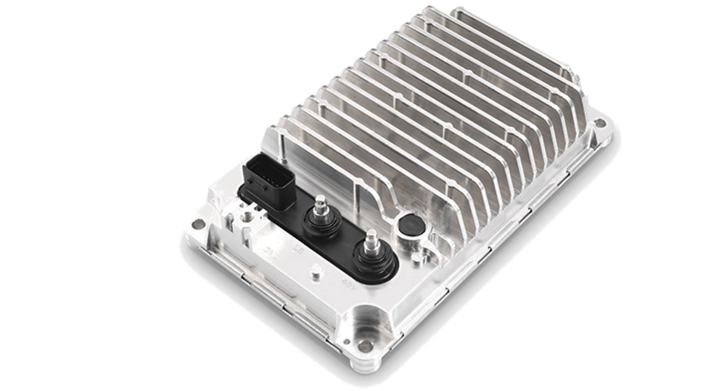 A silver, rectangular electronic device with multiple ridges and two protruding connectors on the left side. The top surface features a series of vertical fins for heat dissipation. The device rests on a white background and appears to be housed in a metallic casing.